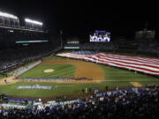 A giant United States flag is displayed during the national anthem before Game 3 of the Major League Baseball World Series between the Cleveland Indians and the Chicago Cubs in Chicago. The anthem has been a standard part of U.S. sports games since World War II. Experts say Game 1 of the 1918 World Series between the Boston Red Sox and the Chicago Cubs helped pave the way. The song became the official national anthem in 1931.