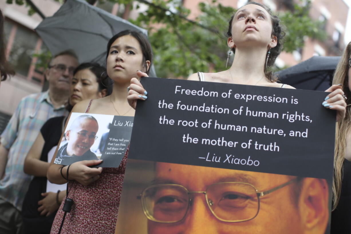 A woman holds a placard with a photo and quotation of Liu Xiaobo on Thursday in New York during a vigil honoring his legacy.