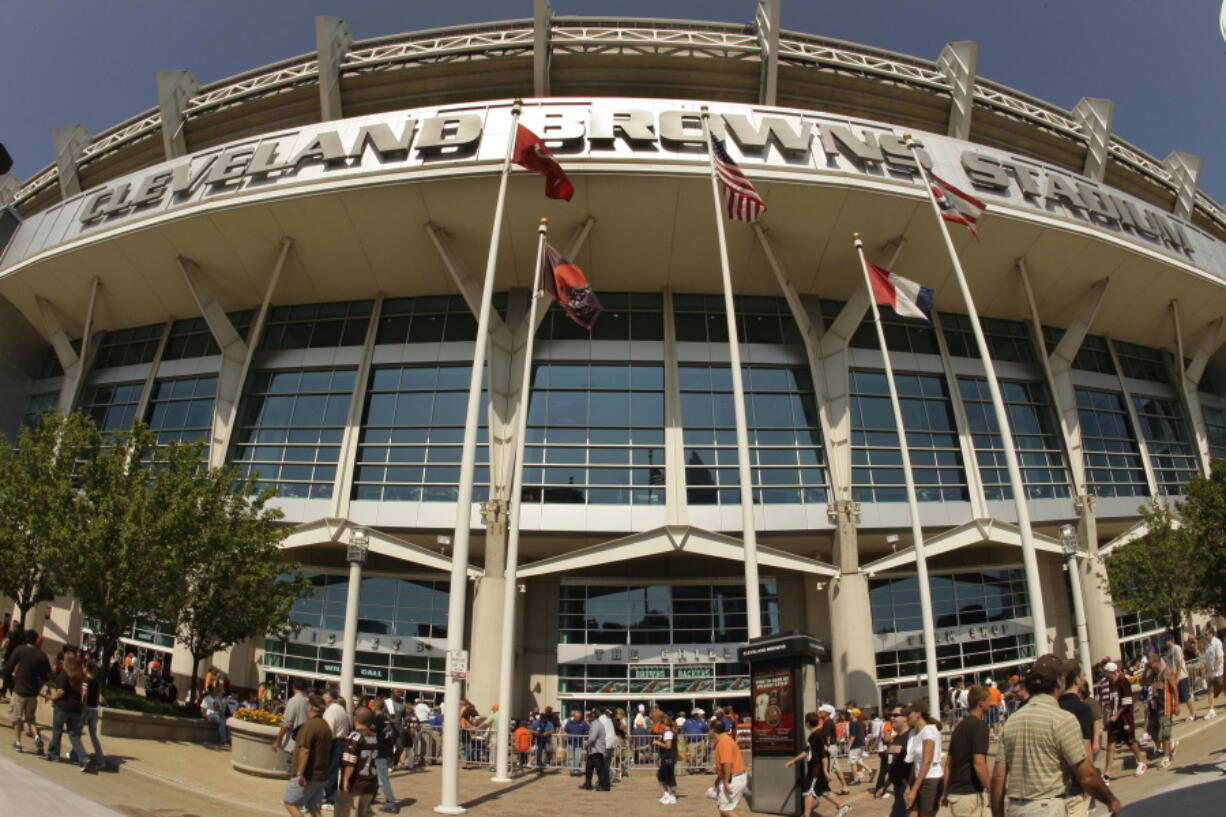 In this Sunday, Sept. 13, 2009 file photo, fans walk into Cleveland Browns Stadium before the Minnesota Vikings play the Cleveland Browns in an NFL football game, in Cleveland. In sales brochures, a U.S. company boasted of the “stunning visual effect” its shimmering aluminum panels created in an NFL stadium, an Alaskan school and a 33-story hotel on Baltimore’s waterfront.