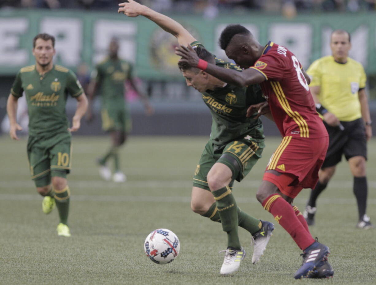 Portland Timbers’ Ben Zemanski (14) holds possession against Real Salt Lake’s Sunday Stephen during an MLS soccer match Wednesday, July 19, 2017, in Portland, Ore.