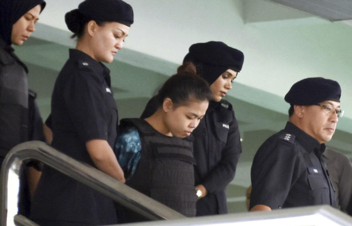 Indonesian Siti Aisyah, center, is escorted out of court by police officers in Shah Alam outside Kuala Lumpur, Friday, July 28, 2017. A lawyer for one of the two women accused of poisoning the half brother of North Korea’s leader said Friday he has doubts about the chemists’ report that showed the banned VX nerve agent was used, as he examined evidence in preparation for a trial set for October. High Court Judge Azmi Ariffin set an Oct. 2 trial date for Indonesian Siti Aisyah and Vietnamese Doan Thi Huong, who are accused of smearing Kim Jong Nam’s face with VX at a crowded airport terminal in Kuala Lumpur on Feb. 13. He died about 20 minutes later.