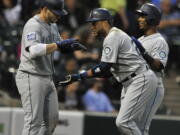 Seattle Mariners’ Robinson Cano center, celebrates with teammates Jean Segura, right, and Nelson Cruz, left, at home plate after hitting a three-run home run during the third inning of a baseball game against the Chicago White Sox, Friday, July 14, 2017, in Chicago.