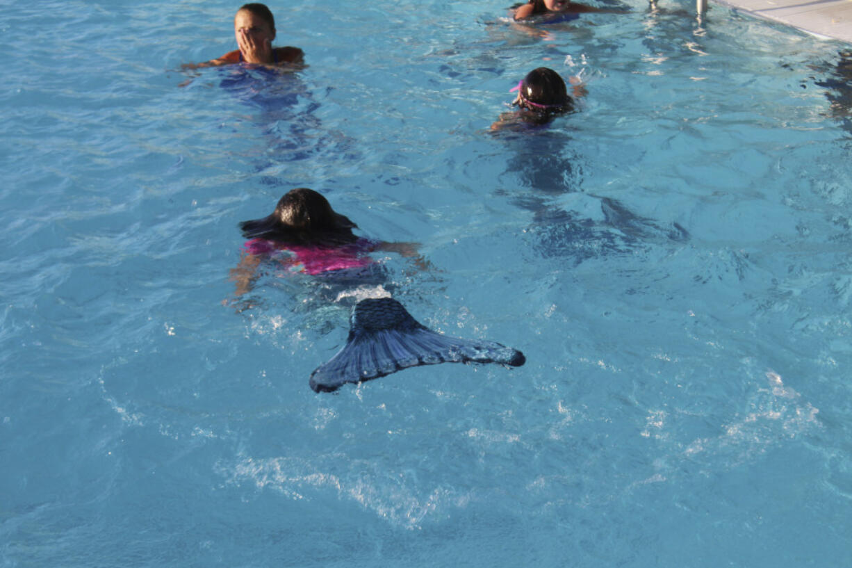 Children take a swim as mermaids July 20 at the Surf 'n Slide Water Park in Moses Lake, Wash. Mermaid School teaches kids how to maneuver while in the water wearing a mermaid tail, but kids need to have some knowledge of swimming before they qualify for school, Lauren Ausere said. Lauren is a Surf ‘n Slide assistant manager and a Mermaid School instructor.