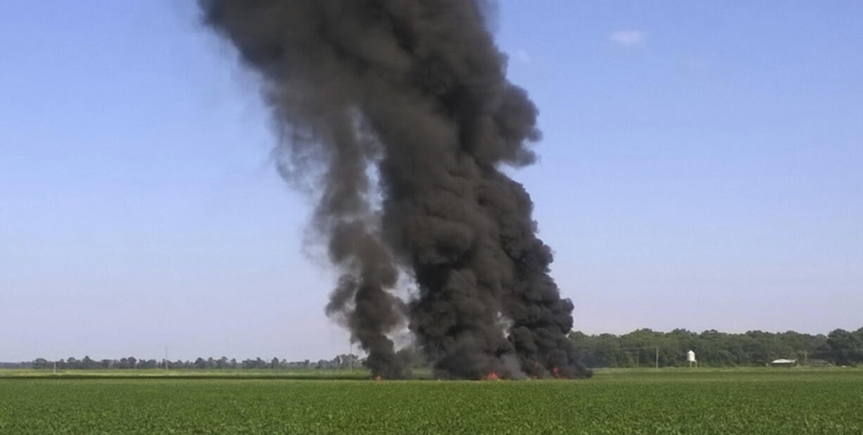 In this photo provided by Jimmy Taylor, smoke and flames rise into the air after a military transport airplane crashed in a field near Itta Bena, Miss., on the western edge of Leflore County, Monday, July 10, 2017, killing several.