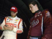 FILE - In this July 5, 2014, file photo, Alex Bowman, right, watches as Dale Earnhardt Jr. sends out a tweet while waiting under a tunnel for driver introductions to begin before a NASCAR Sprint Cup Series auto race at the Daytona International Speedway, in Daytona Beach, Fla. Dale Earnhardt Jr. got the replacement he wanted. Alex Bowman got his dream job. Hendrick Motorsports announced Thursday, July 20, 2017, that the 24-year-old Bowman will replace one of the series’ biggest stars in the No. 88 car next season after Earnhardt retires.(AP Photo/Phelan M.