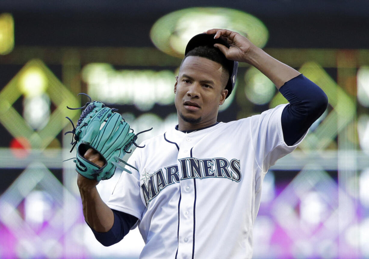 Seattle Mariners starting pitcher Ariel Miranda takes a moment to tug on his cap against the Kansas City Royals in a baseball game Wednesday, July 5, 2017, in Seattle.