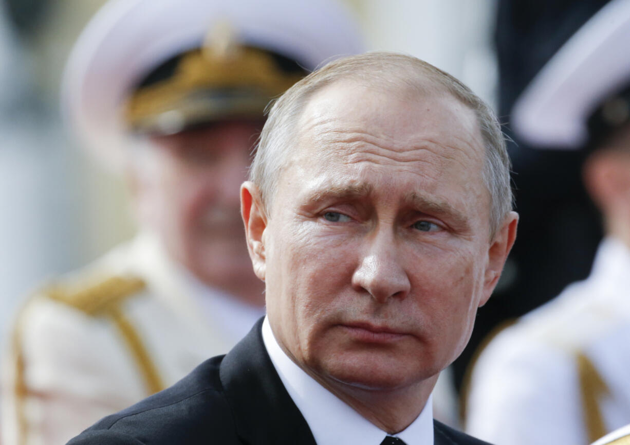 Russian President Vladimir Putin looks on attending the military parade during the Navy Day celebration in St.Petersburg, Russia, on Sunday.