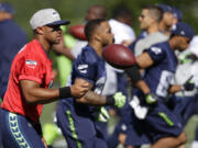 Seattle Seahawks quarterback Russell Wilson tosses the ball during a warm-up drill at NFL football training camp, Sunday, July 30, 2017, in Renton, Wash. (AP Photo/Ted S.