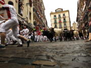 Revelers run in front of Fuente Ymbro’s fighting bulls during the running of the bulls Monday at the San Fermin Festival in Pamplona, Spain.