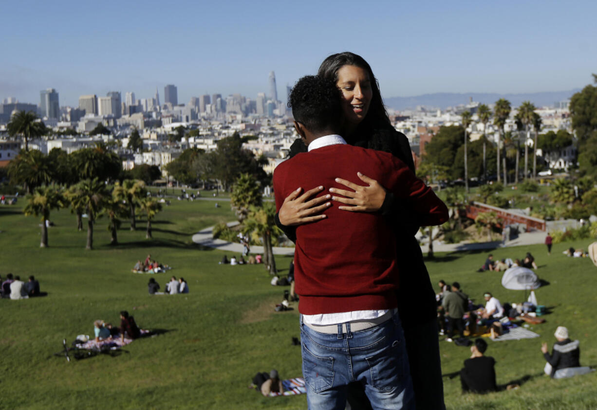 Julie Rajagopal, facing, hugs her 16-year-old foster child from Eritrea on July 14 at Dolores Park in San Francisco. When he landed in March, he was among the last refugee foster children to make it into the U.S. Trump administration travel bans declared to block terrorists also are halting a small, three-decade-old program bringing orphan refugee children to waiting foster families in the United States.