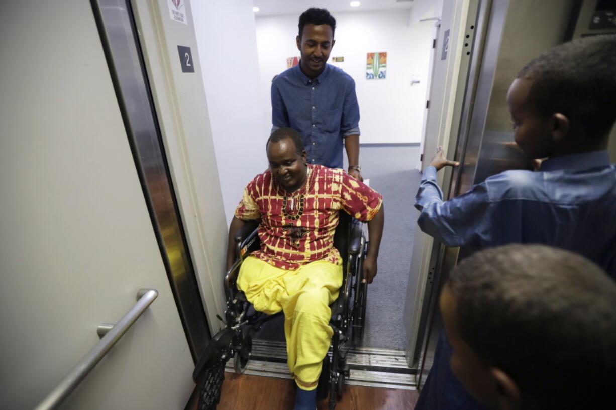 Ali Said of Somalia has his wheelchair pushed by caseworker Mohamed Yassin on July 6 at the International Rescue Committee’s office in San Diego. Said, whose leg was blown off by a grenade in war-torn Somalia years ago, says he feels lucky to be among the last refugees allowed into the United States before stricter rules kick in. He spent eight years being vetted for resettlement. Last year, the father of seven was shot in his remaining leg by robbers while living in a Kenyan refugee camp. The family arrived in California from Kenya on July 6.