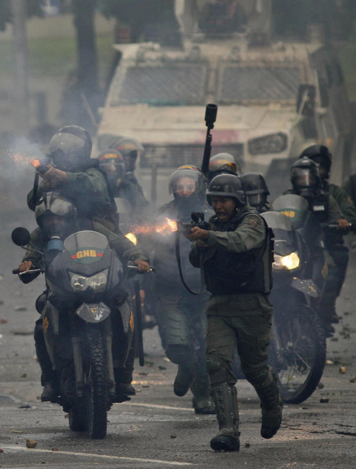 Bolivian National Guard troops fire rubber bullets as they advance toward anti-government demonstrators Friday in Caracas, Venezuela.