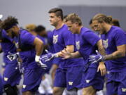 Washington defensive players run through a drill at the team’s first official NCAA college football practice of the year Monday, July 31, 2017, in Seattle.