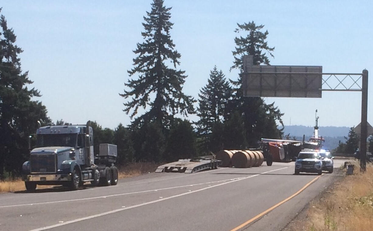 A truck carrying 70,000 pounds of paper rolled onto its side Friday afternoon, snarling traffic at the intersection of Highway 14 and Interstate 205.