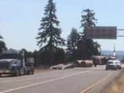 A truck carrying 70,000 pounds of paper rolled onto its side Friday afternoon, snarling traffic at the intersection of Highway 14 and Interstate 205.