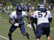 Seattle Seahawks defensive end Marcus Smith, left, lines up against linebacker Michael Wilhoite (57) during an NFL football training camp, Monday, July 31, 2017, in Renton, Wash. (AP Photo/Ted S.