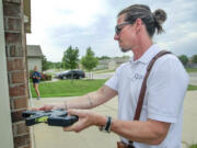 Redemption Church co-pastor Chad Gilstrap measures a home in north Wichita, Kan. He has a real estate appraising business with his wife Jennifer in addition to working at the church.