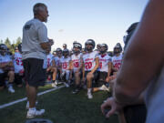 Camas High School coach Jon Eagle talks with his team at the beginning of their first practice in Camas on Wednesday evening, Aug. 16, 2017.