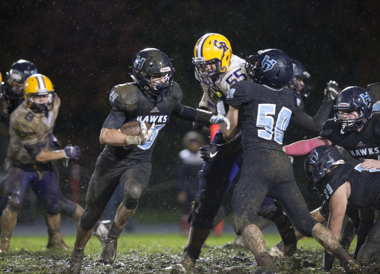 Hockinson's Matt Henry (25) scrambles through the mud for yardage in the third quarter at Hockinson High School on Friday night, Oct. 14, 2016.