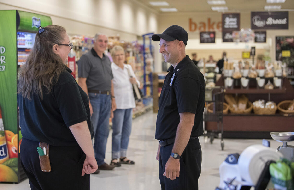 Checker Kim Benson, left, chats with colleague Danny Alder of Ridgefield as he drops by the Salmon Creek Albertsons on his day off. Alder, a childhood cancer survivor, was recently honored for 22 years of employment at Albertsons.