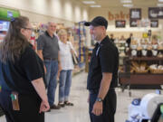 Checker Kim Benson, left, chats with colleague Danny Alder of Ridgefield as he drops by the Salmon Creek Albertsons on his day off. Alder, a childhood cancer survivor, was recently honored for 22 years of employment at Albertsons.
