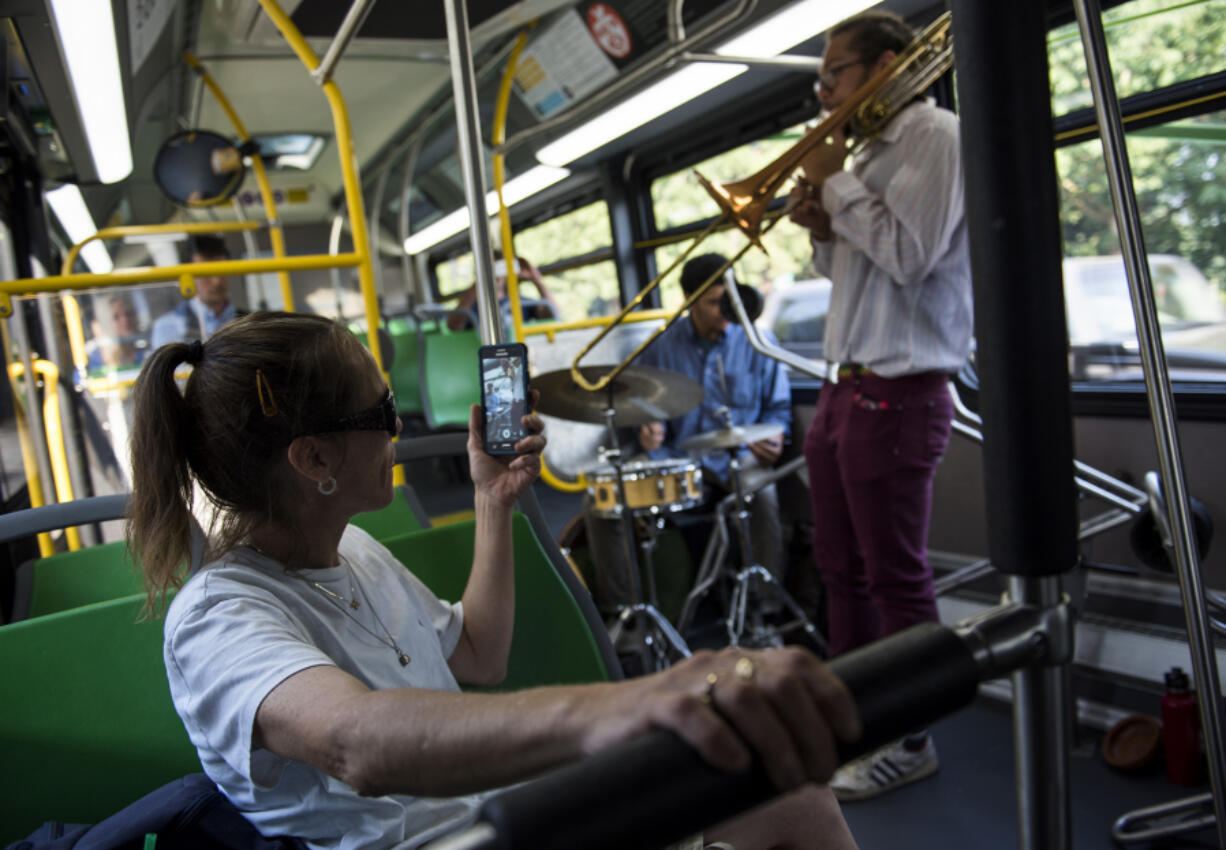 Rejeana Stallings of Vancouver films James Powers Trio as the band plays live jazz on a Vine bus while driving along the Fourth Plain corridor in Vancouver on Friday evening.