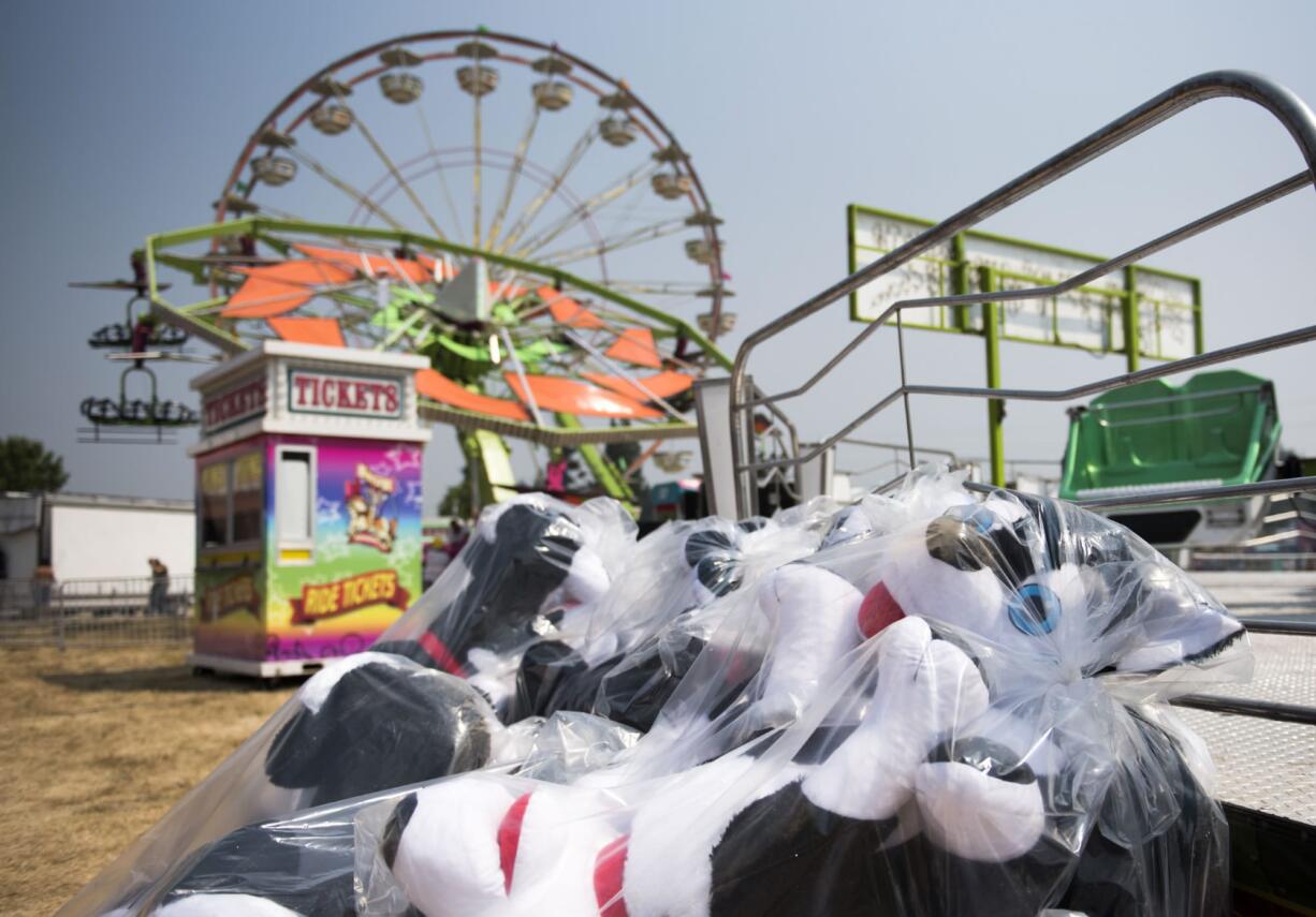 Packaged stuffed animals lie amidst the rides as carnival workers set up the game booths at the Clark County Event Center at the Fairgrounds in Ridgefield on Thursday afternoon. The fair opens its gates Friday and runs through Aug. 13.