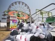 Packaged stuffed animals lie amidst the rides as carnival workers set up the game booths at the Clark County Event Center at the Fairgrounds in Ridgefield on Thursday afternoon. The fair opens its gates Friday and runs through Aug. 13.