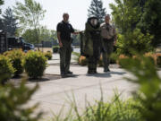 Above: Sheriff’s deputies Jeremy Koch, left, and Chris Luque lead 14-year-old Kenzie Brown, dressed in a full bomb suit, around a simulated crime scene to look for staged explosives. The Tuesday simulation was part of a full week of activities. Left: Deputies Chris Luque, left, and Jeremy Koch, right, help Jayden Pantier of Vancouver, 13, put on a bomb suit.