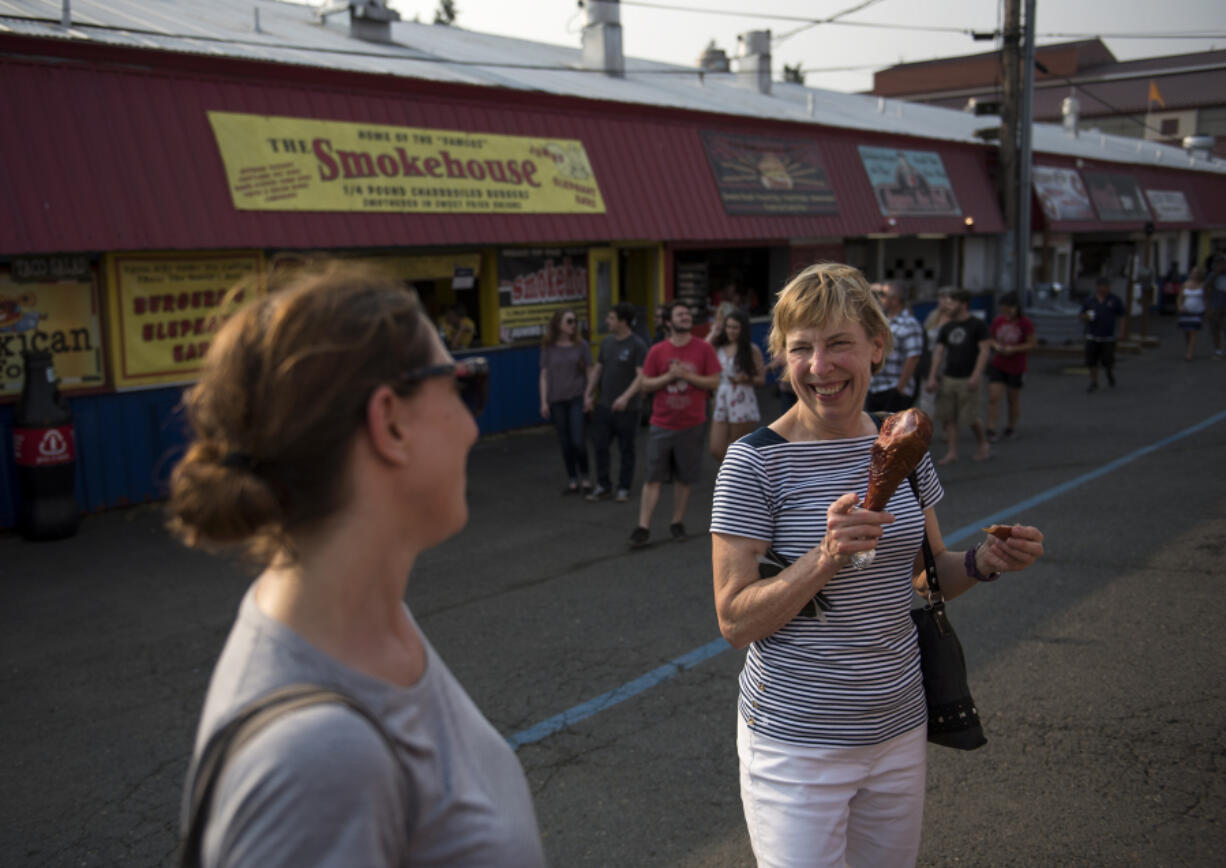 Food writer Rachel Pinsky, left, and dietician Robin Hammon chat as they sample a barbecued turkey leg Thursday at the Clark County Fair.