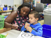 Kindergarten teacher Melissa Bergmann shows Kindergarten Jump Start student Yael Bernat Avila Estrada how to properly hold a crayon during an art project where students learned about the letter “O” at Martin Luther King Elementary School in Vancouver on Monday morning. Through the Vancouver Public Schools Jump Start program, incoming kindergartners get a taste of what their first year of school will be like, including playing with new friends, learning letters and practicing lining up for recess.