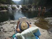 Jessica Magnusen of Tigard, center, relaxes with a good book and a scenic view with visiting Dougan Falls with her kids and friends Wednesday afternoon, Aug. 2, 2017.