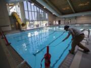 David Dayton of Anderson Poolworks cleans the bottom of the recently renovated Marshall Center pool on Friday morning.