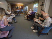 Larry Coatney, a member of Grace Lutheran Church, second from right, shares a song book with memory care client Jerry Knepper, right, while singing traditional Christian hymns at Graceful Living Activity Center on Thursday afternoon.