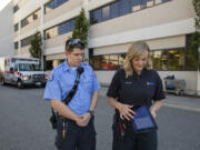 Paramedic Patricio Bustos, left, and paramedic field training officer Brooke Marling of American Medical Response demonstrate how to use the app, Pulsara, Wednesday at PeaceHealth Southwest Medical Center. Local emergency responders began using the app in late May to transmit information to the hospital will en route with patients.