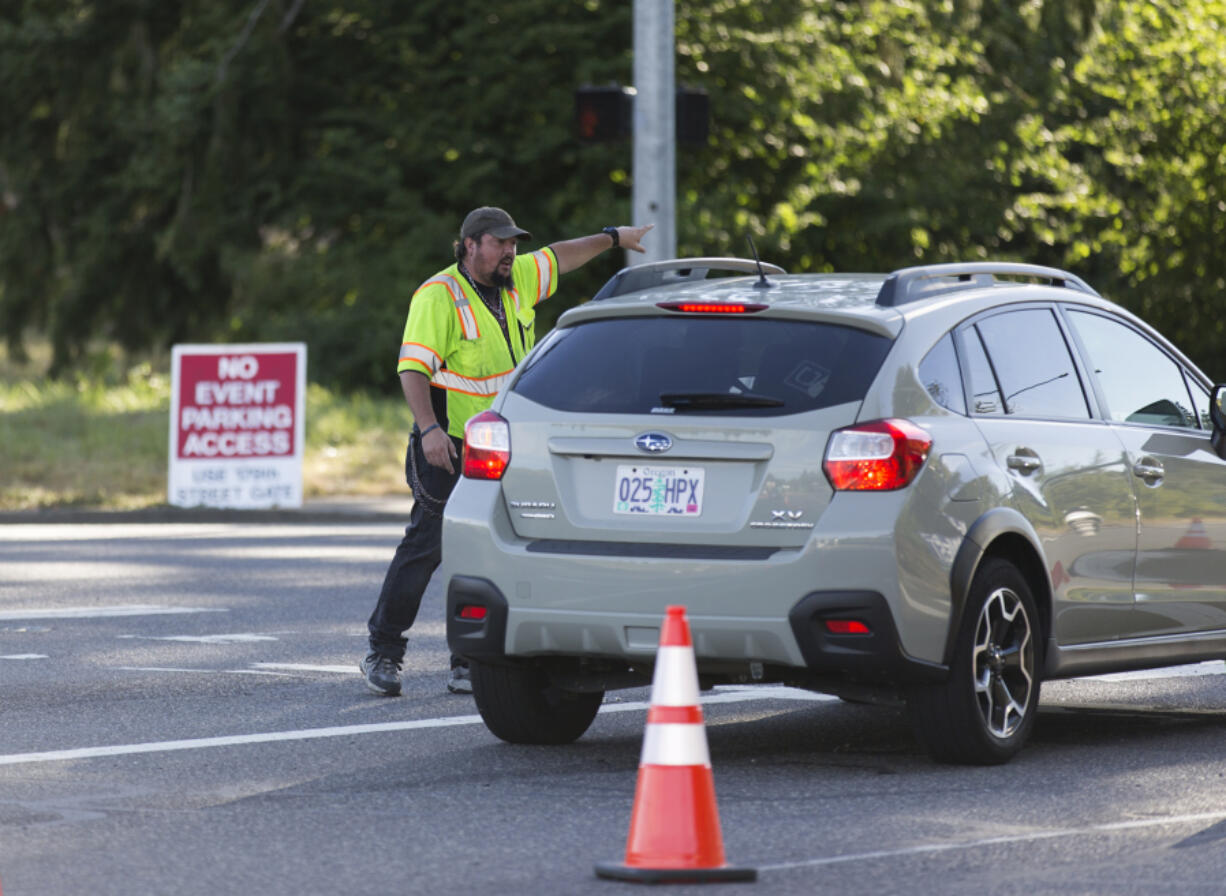 Sunlight Supply Amphitheater traffic flagger Chad Cooper directs traffic before an Incubus concert in Ridgefield. Neighbors of the amphitheater say traffic issues have gotten worse over the past few years.