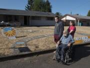 Tom Laidlaw, center; his grandson, Doug Brouhard, left; and his daughter, Debra Brouhard, look over the sundial garden Laidlaw created in his Vancouver Heights neighborhood front yard.