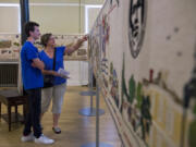 Andrew Douglas of Vancouver, 14, and his mother Sara Douglas discuss sections of the Fort Vancouver Tapestry at the Artillery Barracks on Tuesday. Sara had seen the tapestry when Andrew was younger and wanted to bring him back so they could look over it together.