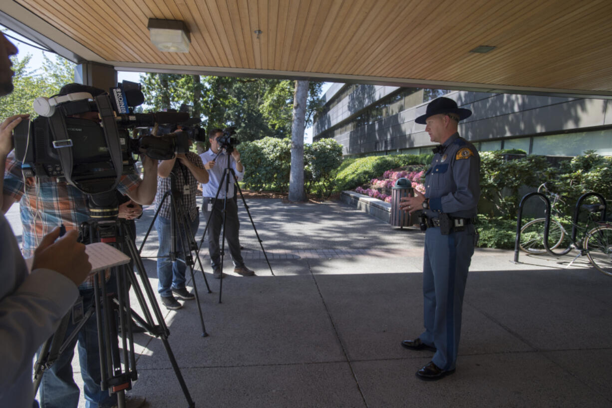 Trooper Will Finn, right, speaks to members of the media outside Washington State Patrol headquarters in Vancouver on Friday about the two crashes this year when victims were not found immediately by the State Patrol.