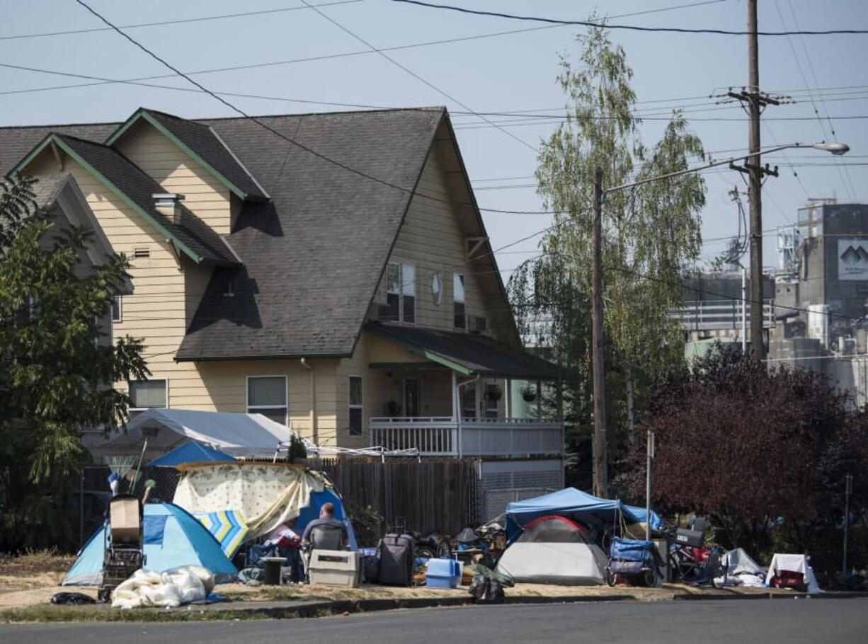 Tents and belongings line the street edge outside Share House, the men’s homeless shelter on the west edge of downtown Vancouver.