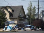 Tents and belongings line the street edge outside Share House, the men’s homeless shelter on the west edge of downtown Vancouver.