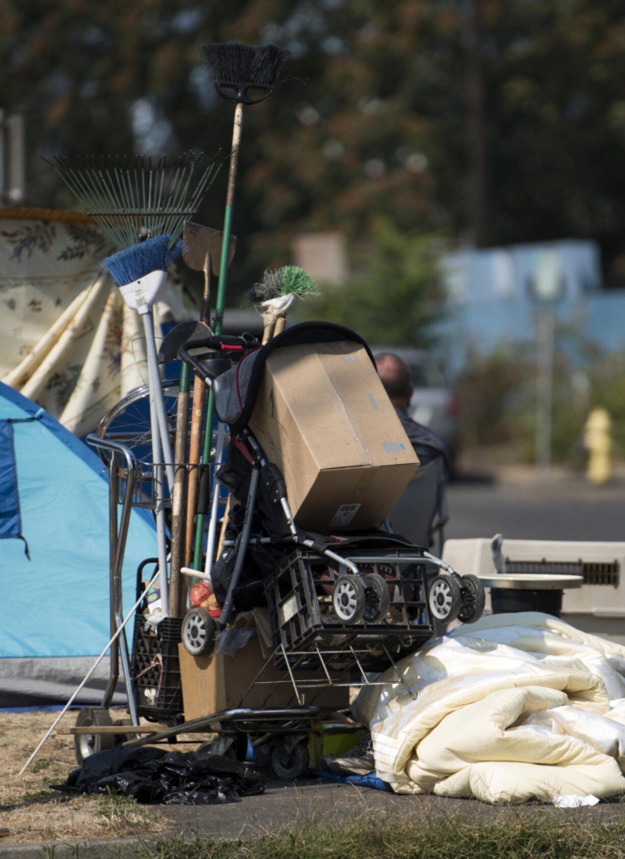 A cart with tools and belongings sits on the street edge outside Share House.