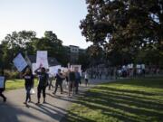 People walk through Esther Short Park during a Save DACA rally hosted by the League of United Latin American Citizens Wednesday evening in downtown Vancouver.