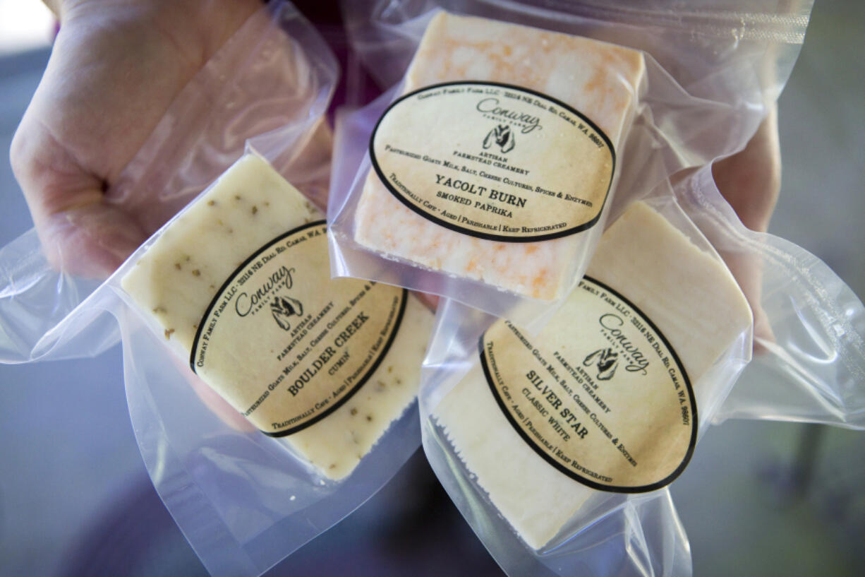 Lorrie Conway holds three varieties of cheese sold by Conway Family Farm in Camas.