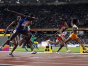 United States' Tori Bowie, left, crosses the line to win the gold in the women's 100-meter final during the World Athletics Championships in London Sunday, Aug. 6, 2017.