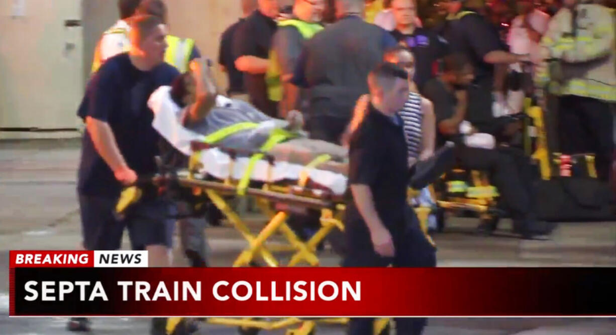 In this frame from video, a person is pulled away from the scene of a train crash in Upper Darby, Pa., Tuesday, Aug. 22, 2017. A commuter train crashed into a parked train at the suburban Philadelphia terminal early Tuesday morning, injuring dozens of passengers, a transit spokeswoman said.