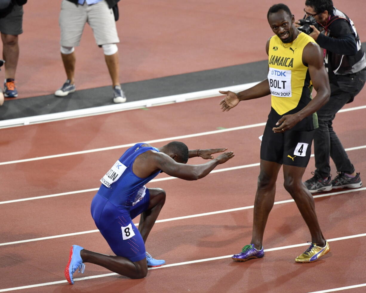 Justin Gatlin, ganador de la medalla de oro, se arrodilla frente a Usain Bolt, ganador del bronce, tras la final de los 100 metros en el Mundial de atletismo, en Londres, el sábado 5 de agosto de 2017.