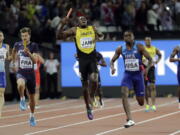 Jamaica's Usain Bolt, center, pulls up injured in the final of the Men's 4x100m relay during the World Athletics Championships in London Saturday, Aug. 12, 2017. At right is United States' Christian Coleman. (AP Photo/David J.