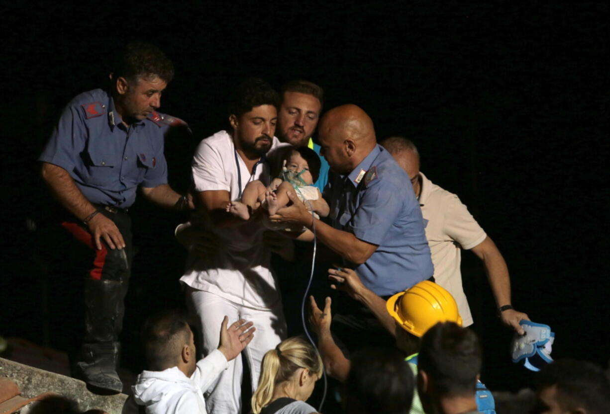 Rescuers pull out 7-month boy Pasquale from the rubble of a collapsed building in Casamicciola, on the island of Ischia, near Naples, Italy, a day after a 4.0-magnitude quake hit the Italian resort island Tuesday. Hospital officials on the Italian resort island of Ischia say that three brothers rescued from the rubble of their home after a 4.0-magnitude quake are all in good condition.