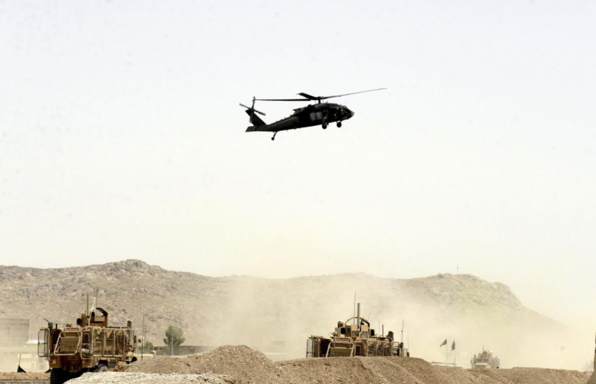 A U.S. military helicopter flies over the site of a suicide bomb that struck a NATO convoy in Kandahar south of Kabul, Afghanistan, Wednesday. A suicide bomber struck a NATO convoy near the southern Afghan city of Kandahar on Wednesday, causing casualties, the U.S. military said.